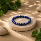 Blue beaded bracelet on a stone surface with natural light and greenery